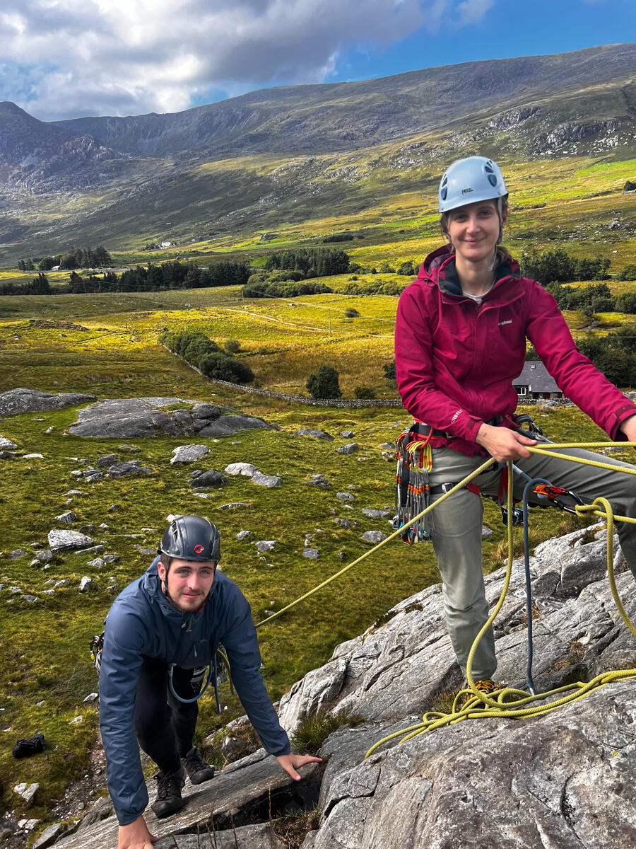 Rock Climbing Instructor Image of two people climbing in harnesses and using ropes